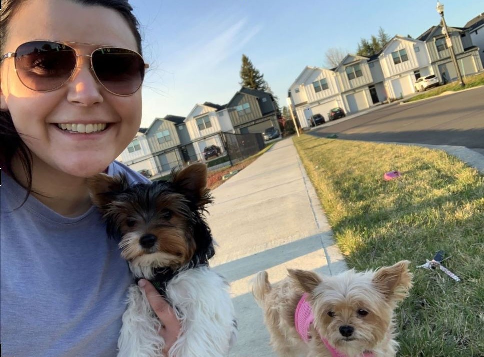 Young woman with two cute dogs in a residential neighborhood.